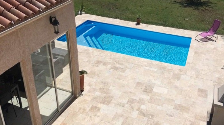 piscine coque thelma bleue avec terrasse travertin